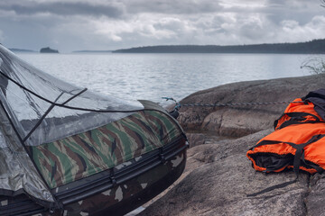 An inflatable motor boat on the north lake and an orange life jacket on the shore. 