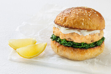 A healthy burger with fishcake, spinach and cream cheese. Whole grain bun. Healthy eating concept