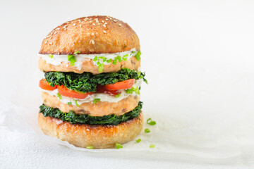 A healthy burger with fishcake, spinach and cream cheese. Whole grain bun. Healthy eating concept
