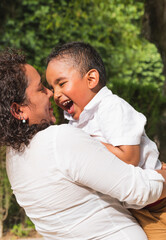 Fototapeta premium Latin mother and son having fun in the park.