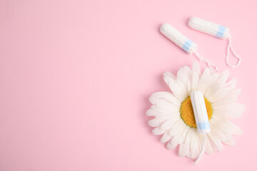 Tampons and chamomile on light pink background, flat lay. Space for text