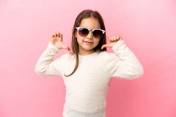 Little caucasian girl isolated on pink background proud and self-satisfied