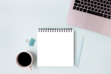 Workspace with laptop and notebook mockup on a blue background. Distance work, online education concept.