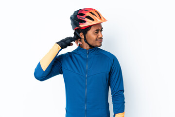 Young cyclist man with braids over isolated background having doubts while scratching head