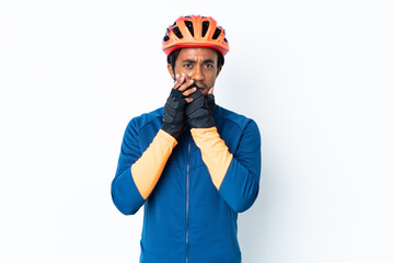 Young cyclist man with braids over isolated background covering mouth with hands