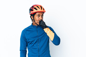 Young cyclist man with braids over isolated background doing surprise gesture while looking to the side