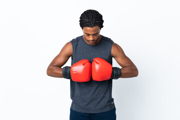 Young African American man with braids isolated on purple background with boxing gloves