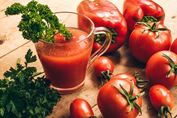 Red pepper and fresh tomatoes on a wooden table. Tomato juice with salt.