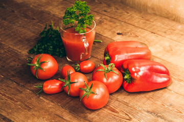 Red pepper and fresh tomatoes on a wooden table. Tomato juice with salt.