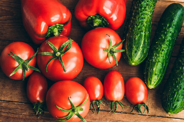 Red pepper and fresh tomatoes and pickles on a wooden table.