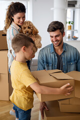 Happy family unpacking boxes in new home on moving day