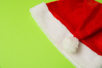 Obraz na płótnie Canvas Santa claus hat on bright green background close up copy space