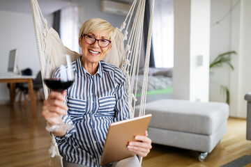 Attractive senior woman using a tablet computer relaxing at home