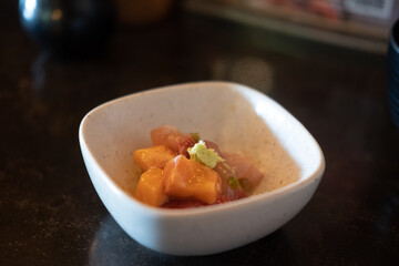 Mixed small pieces of assorted sashimi and tuna on top with wasabi