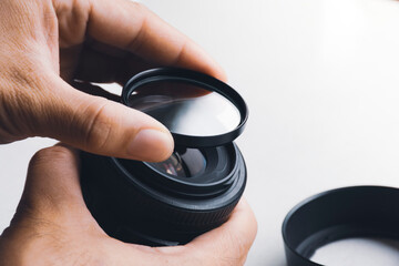 Human hand is installing UV filter to camera lens