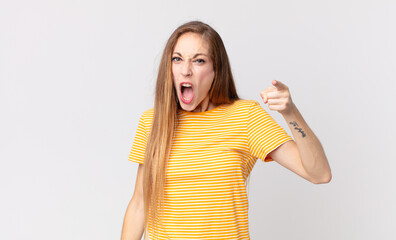 pretty thin woman pointing at camera with an angry aggressive expression looking like a furious,...