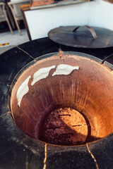 Baking flatbreads for making khachapuri in a traditional tandoor oven. National Georgian and Caucasian cuisine