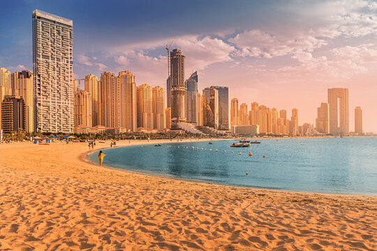 Panoramic view of the golden sand illuminated by the setting sun in the JBR beach area. Amazing skyscrapers and warm waters of the Persian Gulf are waiting for guests and tourists