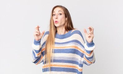 pretty thin woman crossing fingers anxiously and hoping for good luck with a worried look