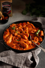 Chicken paprikash dish with paprika onion bulgarian paper on pan on dark table with napkin for...