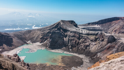 An unusual acid lake on the top of the volcano is surrounded by steep rocky slopes. Lifeless...