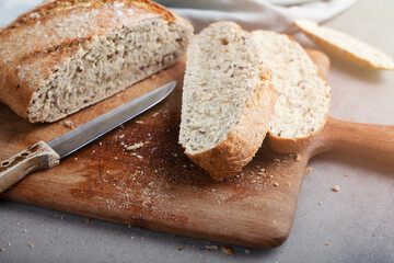 Fresh bread slice and cutting knife on table