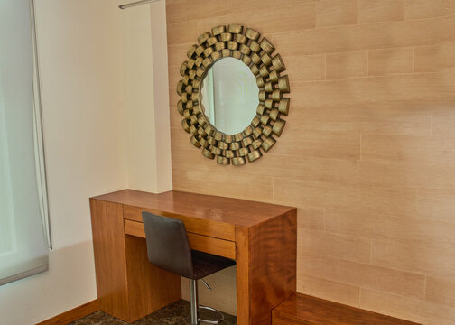 Peinador moderno de madera cuadrado y minimalista de una habitaci&oacute;n de hotel, con un espejo de lujo redondo