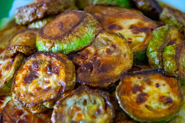 Grilled zucchini, courgette with garlic and rosemary on plate, top view