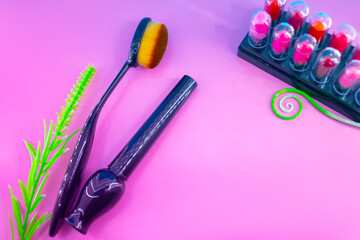 Different makeup cosmetics and accessories on a pink and blue background