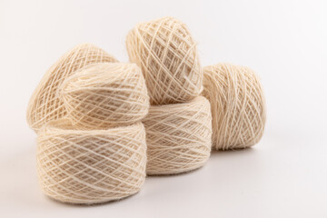 balls of light woolen thread on white background. natural wool. knitting. background