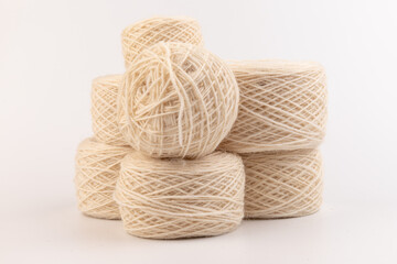balls of light woolen thread on white background. natural wool. knitting. background