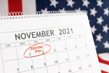 USA election day concept. Desk calendar with November 2rd 2021 marked in red and USA flag at background