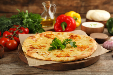 Delicious khachapuri with cheese on wooden table