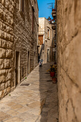 wąska uliczka miedzy starymi kamiennymi budynkami, Giovinazzo, Puglia, Włochy