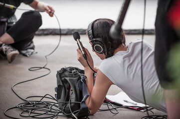 Behind the scene. Sound boom operator resting on the set and hold microphone fisher outdoor © guruXOX