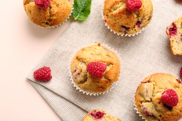 Tasty raspberry muffins on color background, closeup