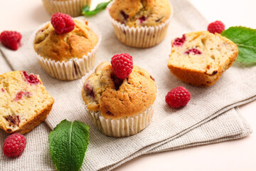 Tasty raspberry muffins on color background, closeup