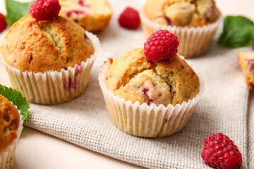 Tasty raspberry muffins on color background, closeup
