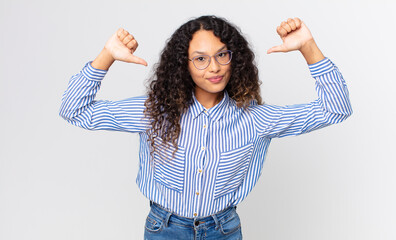 pretty hispanic woman feeling proud, arrogant and confident, looking satisfied and successful,...