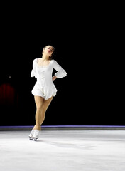 Ice skater with a beautiful pose wearing white dress and showing her dedication to acting