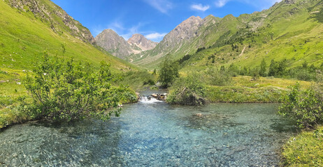 river in alpine valley with peak mountain  background