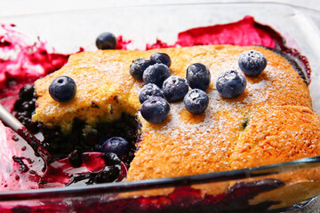 Baking dish with blueberry cobbler on table, closeup