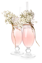 Glasses with tasty cocktail and beautiful gypsophila flowers on white background