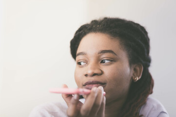 Sad woman of African race speaks by smartphone while holding it in front of face