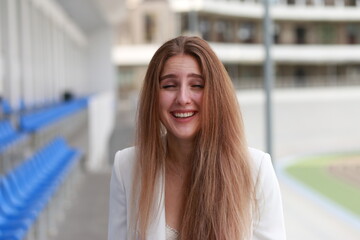 Emotional face of fair-haired young woman at stadium
