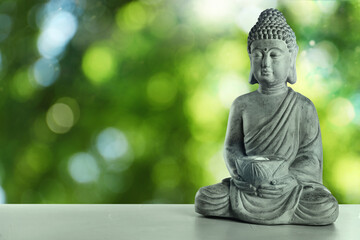 Stone Buddha sculpture on table outdoors. Space for text