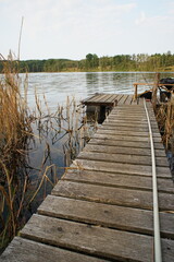 Wooden bridge for anglers on the shore of the lake 