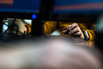 Hands of a person with colourful sweeter  typing on a computer keyboard