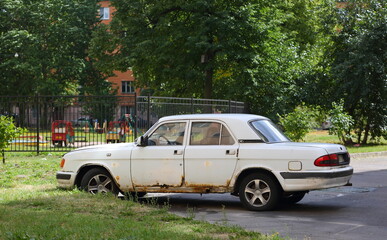Obraz na płótnie Canvas An old white Soviet car is parked in the courtyard, ulitsa Sedova, St. Petersburg, Russia, July 2021