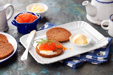 Homemade rye bread slices with butter and red caviar, selective focus